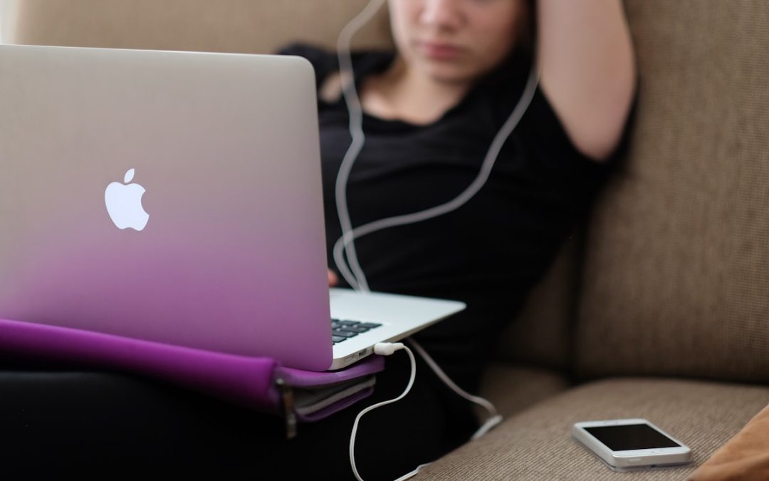 Person at a laptop rubbing their tense neck and shoulder, illustrating tech neck from desk work