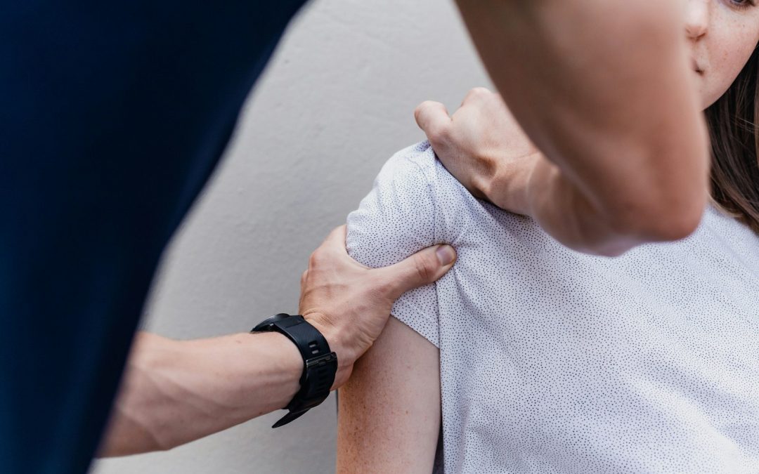 Osteopathic practitioner gently assessing a patient's shoulder