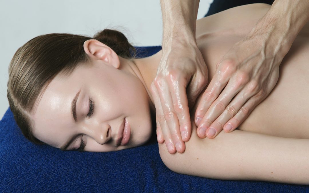 Massage therapist working on a client's neck and shoulders during a massage therapy session